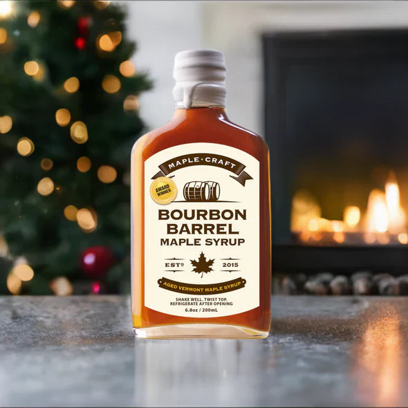 Bottle of Bourbon Barrel Maple Syrup on a table with a festive background