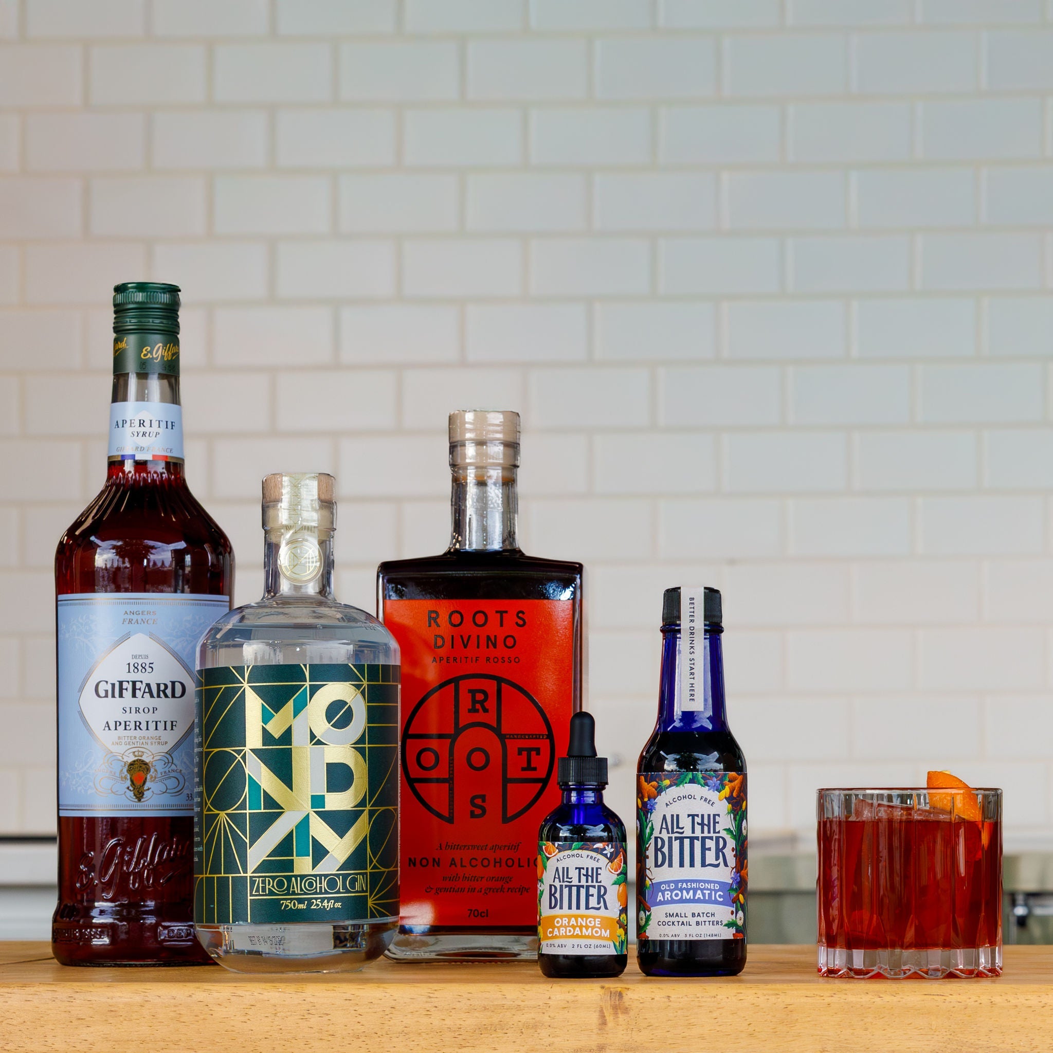 non alcoholic negroni cocktail with bottles of non alcoholic spirits and bitters